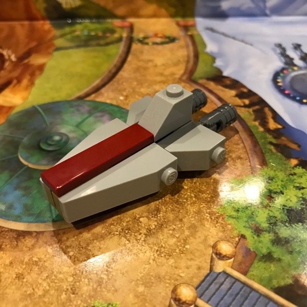 LEGO micro-scale model of a Venator-Class Republic Attack Cruiser, which is a gray triangular ship with a dark red stripe down the middle, a midline gap, and a vertical tail fin. This model has a much narrower midline gap.