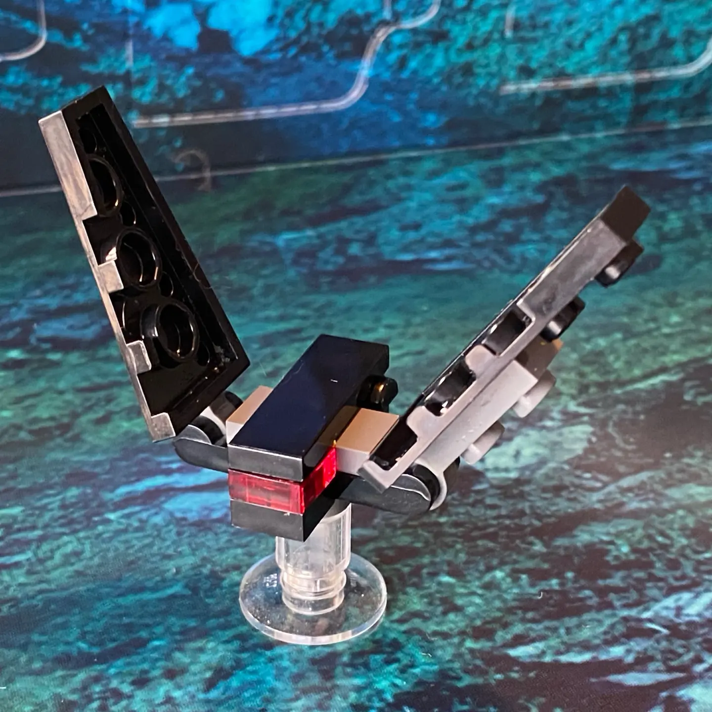 LEGO micro-scale model of a black shuttle with two side wings and no top wings and a red windscreen. It looks like a malevolent bat.