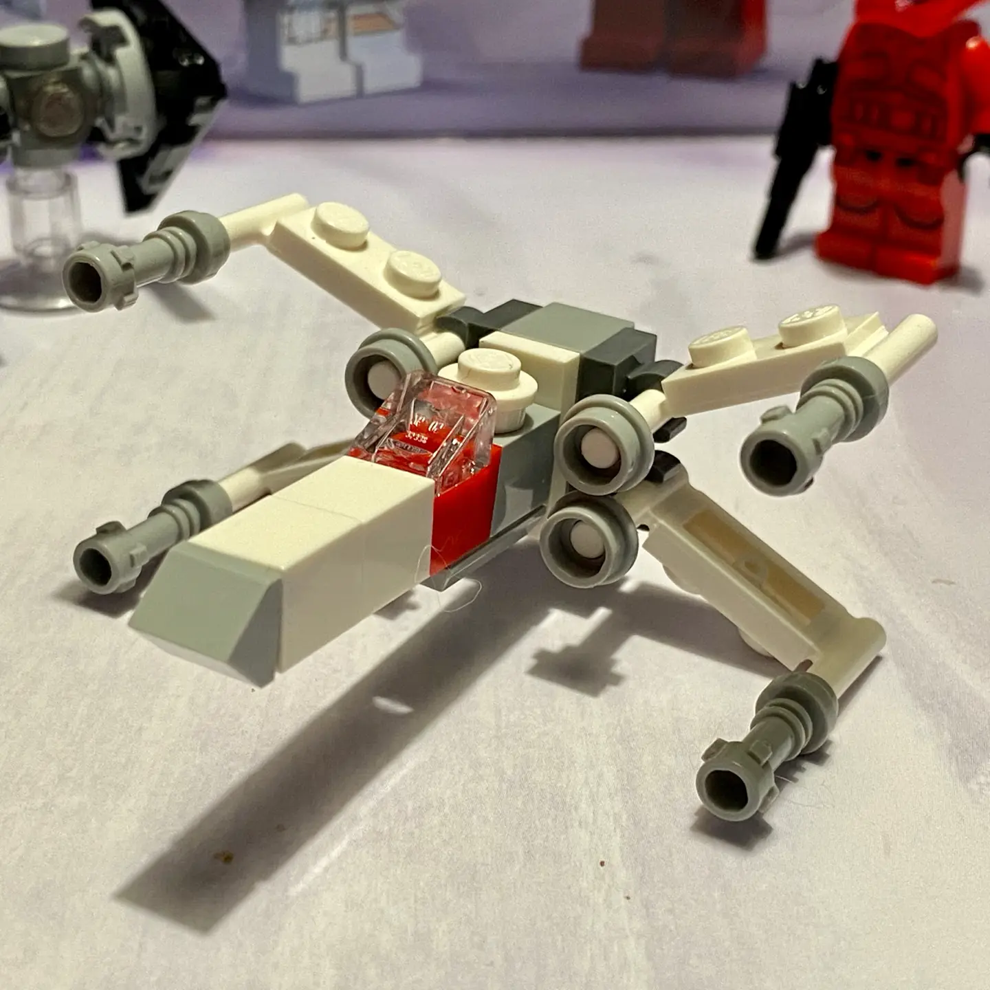 LEGO microscale build of an X-Wing Starfighter from the 2020 advent calendar built in a holiday (white with red highlights) color scheme