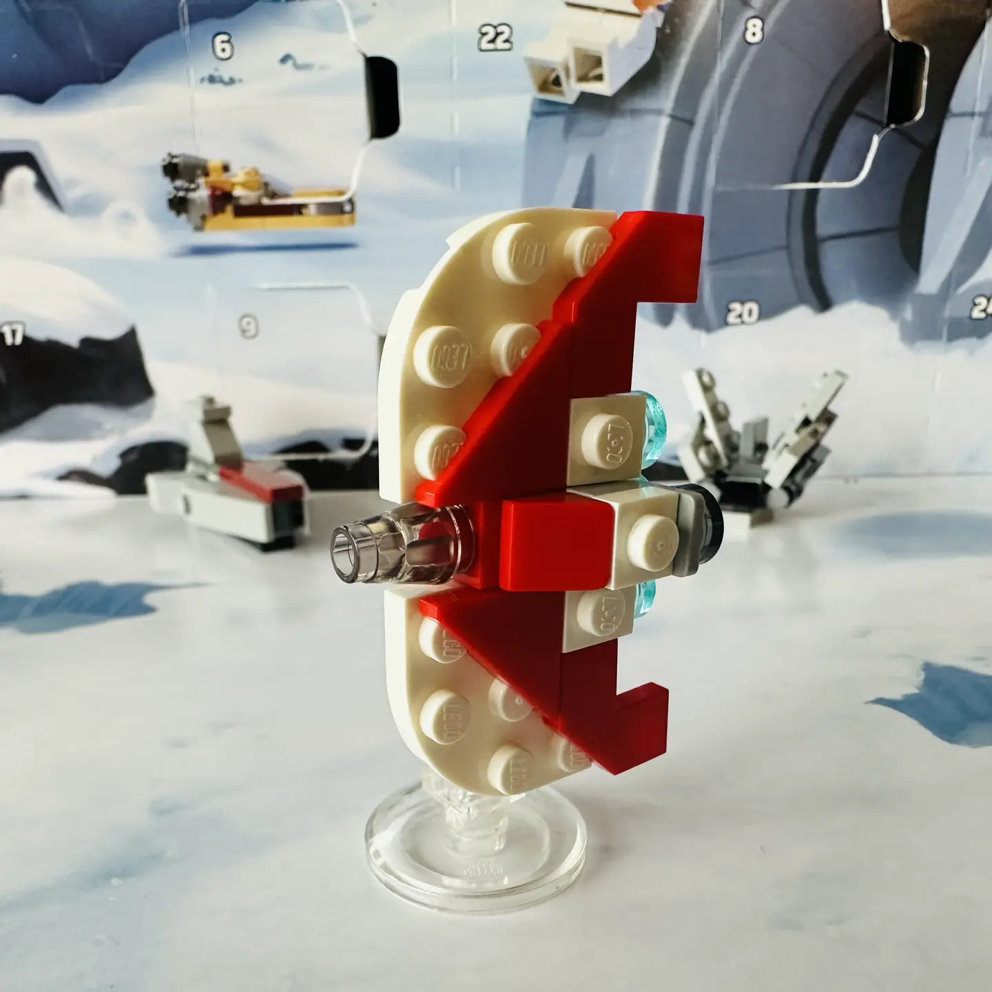 LEGO micro-scale model of a white spaceship with red trim rotated to vertical (so that wings are on top and bottom)