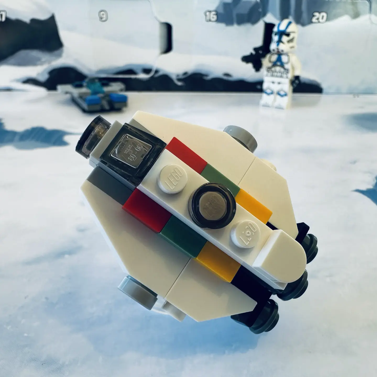 LEGO micro-scale build of the Ghost spaceship in white with red, green, and yellow highlights