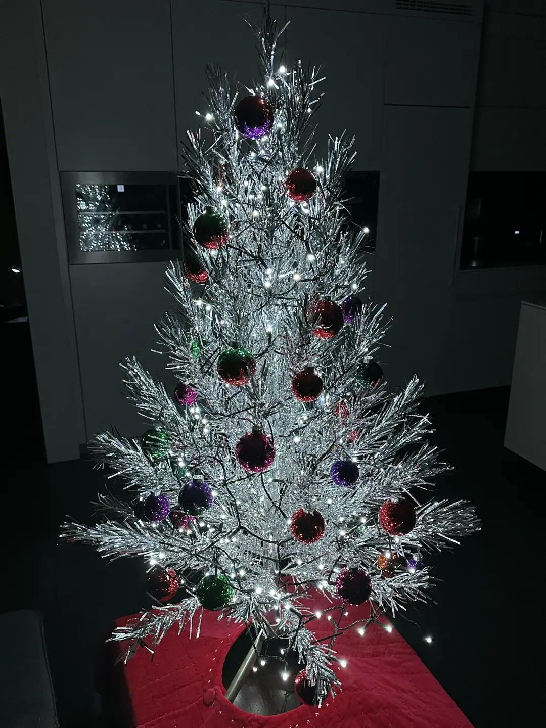 Aluminum Christmas tree decorated only with glass balls and white string lights (Philips Hue Winter Mountain scene).