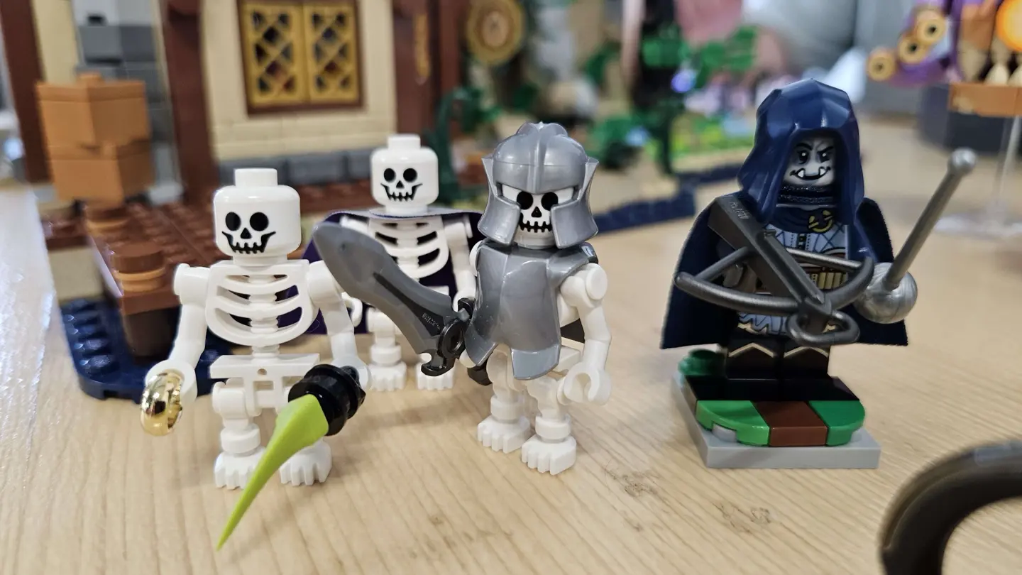 Three LEGO skeletons (equipped as rogue, wizard, and fighter) stand next to the orc rogue minifig