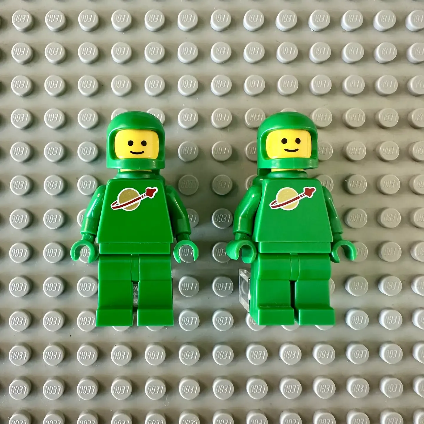 Two green LEGO Classic Space astronaut minifigures.