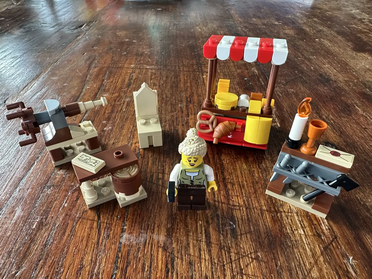 LEGO cheesemaker's cart, several small builds for a carpenter's workshop, and a female carpenter minifigure