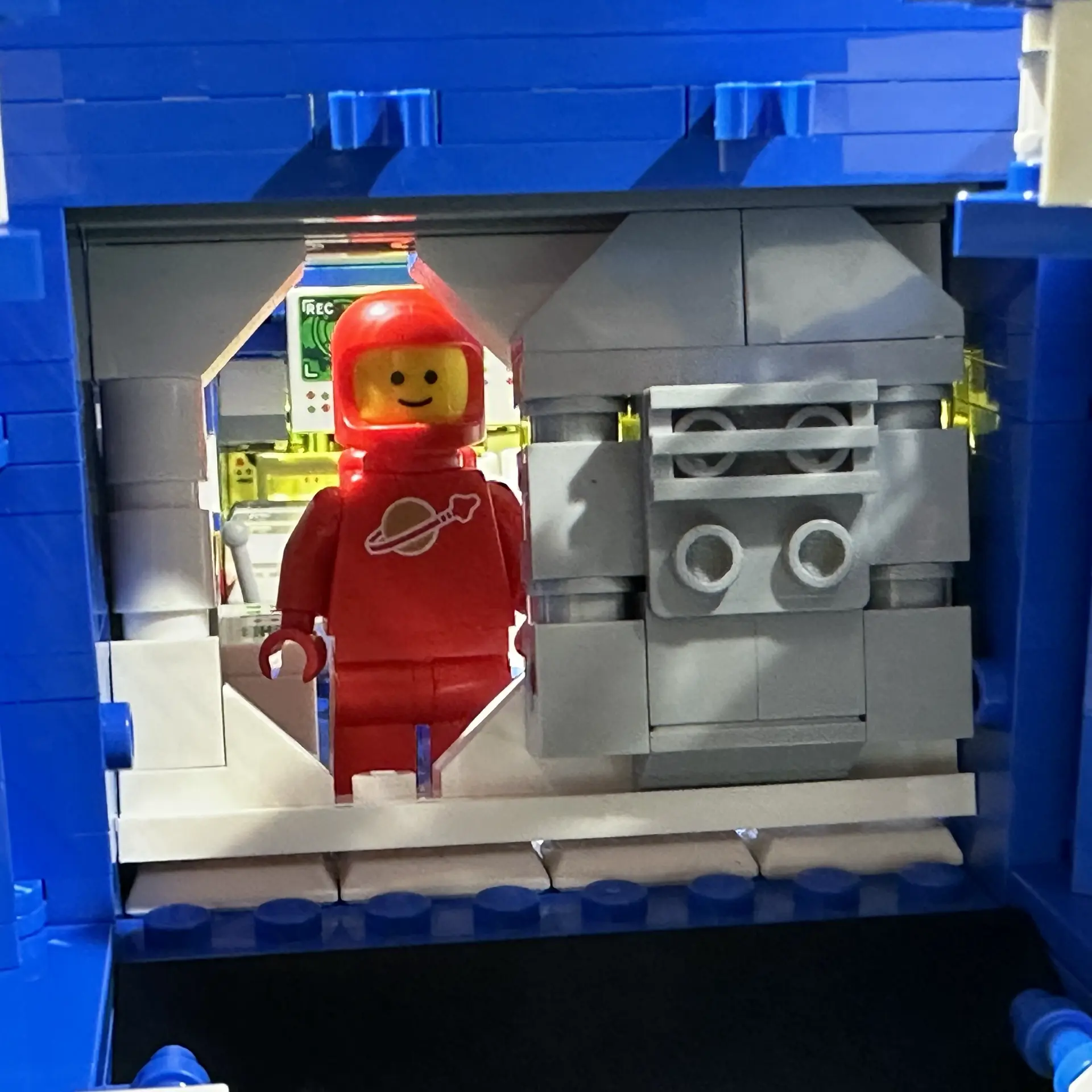 Closeup of the open airlock with sliding door. A red astronaut stands on the other side of the airlock doorway