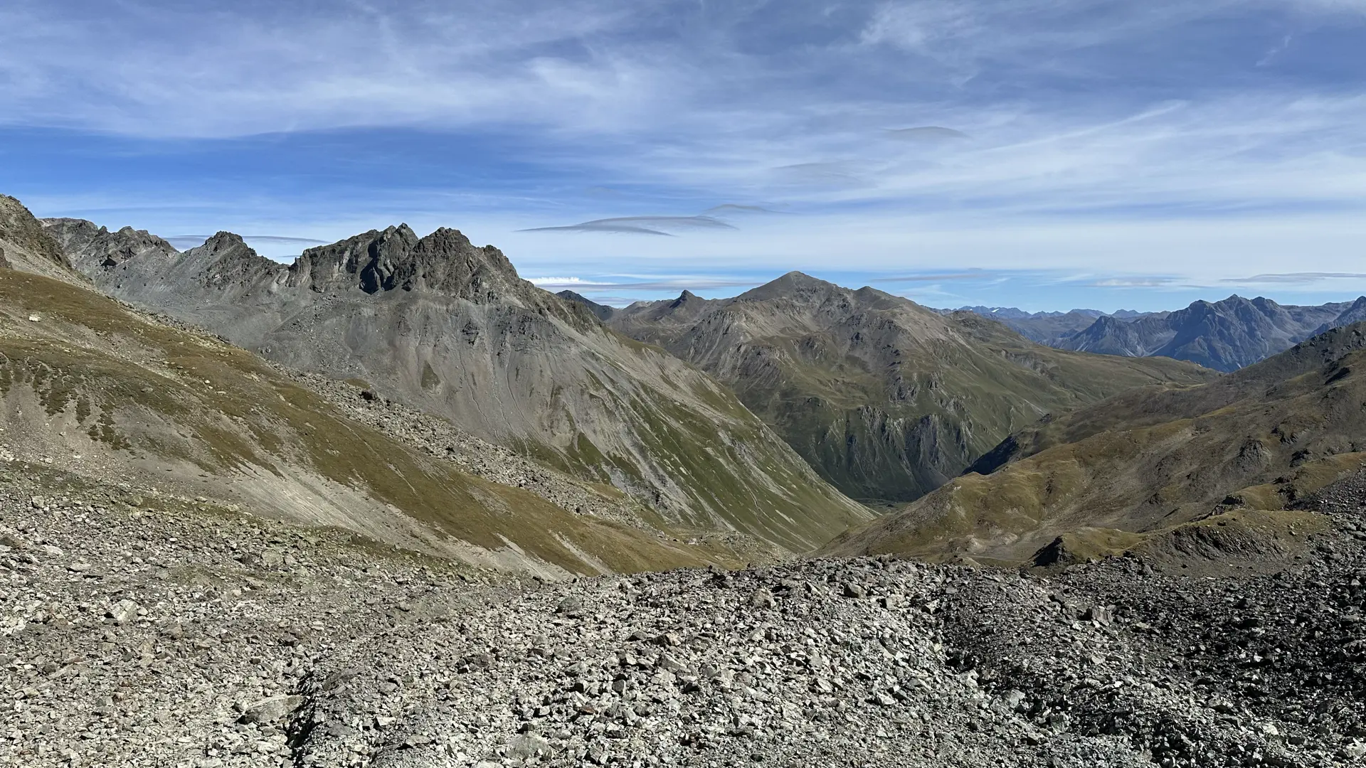 View into an isolated high alpine valley taken from a scree-filled pass